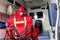 Male paramedic with face mask helping a patient with respirator in ambulance during pandemic. A portrait of paramedic sitting in