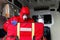 Male paramedic with face mask helping a patient with respirator in ambulance during pandemic. A portrait of paramedic sitting in