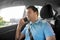 Male passenger calling on smartphone in taxi car