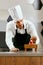 Male Pastry Cook Decorating Dessert In Kitchen