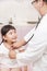 Male pediatrician examining little girl