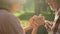 Male pensioner tenderly holding female hand on romantic date in park, closeup