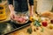 Male person cooking meat with herbs in a pan