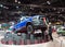 Male person dusting an elevated blue RAM pickup truck displayed at the Chicago Auto Show