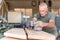 Male person focused working with a hand sander