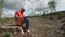 male person in helmet sits on stump of logging territory