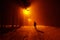 Male person silhouette in dark street countryside road with snow winter