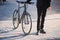 Male person in a suit holding a commuter bike.