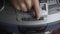 Male person with wrinkled hand press play button on vintage tape recorder.