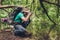 Male photographer is near the lake outdoors in the spring wood, taking shot of beautiful nature! He is a tourist, hiking in jungle