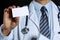 Male physician hand holding white blank calling card closeup