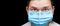 Male physician portrait in blue medical mask with a surprised look raising his eyebrows up.