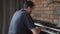 A male pianist plays a digital electronic piano at home