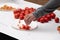 Male picking tomato pieces from a samples table