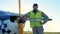 Male pilot stands near a light private airplane. A person stands near a small plane, looking and smiling at camera.