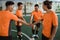 Male players in orange uniforms gather in a circle