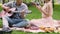 Male playing guitar and singing song with girlfriend park picnic, friends rest