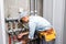 Male plumber checks pipes for central hot and cold water supply of apartment