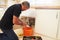 Male plumber preparing a pipe for the sink in a kitchen