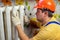 Male plumber repairing the battery in a helmet and with wrench