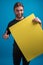 Male portrait displaying ok sign while holding a yellow poster cardboard