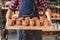 Male potter hands holding tray with baked ceramic pots in the pottery.