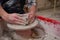 Male potters hand making a pot