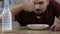 Male pouring milk and eating cereal breakfast with pleasure, healthy nutrition