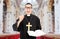 Male priest reading a prayer in church