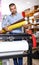 Male printing worker with rolls of colored paper