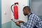 Male Professional Checking A Fire Extinguisher