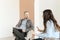 A male psychologist listens attentively to a female patient.