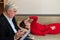 A male psychotherapist writes on a clipboard during a patient consultation. An emotional woman in a red dress lies on a