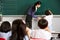 Male Pupil Writing On Blackboard In Chinese School