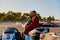 Male racer in protective overalls holding helmet on go-kart track outdoors