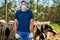 Male rancher in a mask virus protectionon at farm with dairy cows.