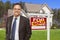 Male Real Estate Agent in Front of Sold Sign and House