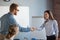 Male recruiter handshaking female job candidate after successful