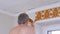 Male Removing Off Old Paper Wallpaper on the Wall. Back View. 4K