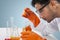 Male researcher analyzing chemical liquid on studio