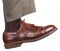 Male right leg in brown shoe takes a step