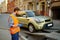 Male road worker monitoring car loading process