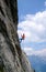 Male rock climber abseiling off a steep rock climbing route in the Swiss Alps after a hard climb