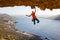 Male rock climber on challenging route going along ceiling in cave