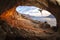 Male rock climber climbing along a roof in a cave