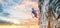 Male rock climber resting while climbing the challenging route on the rocky wall