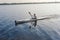 Male rower canoeing in quiet water on sunset