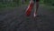 Male runner in bright footwear jogging on ground trail in forest.