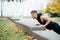 Male runner doing exercise, workout in the fall park. Push ups with bench.