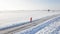 Male runner jogging on winter snowy road